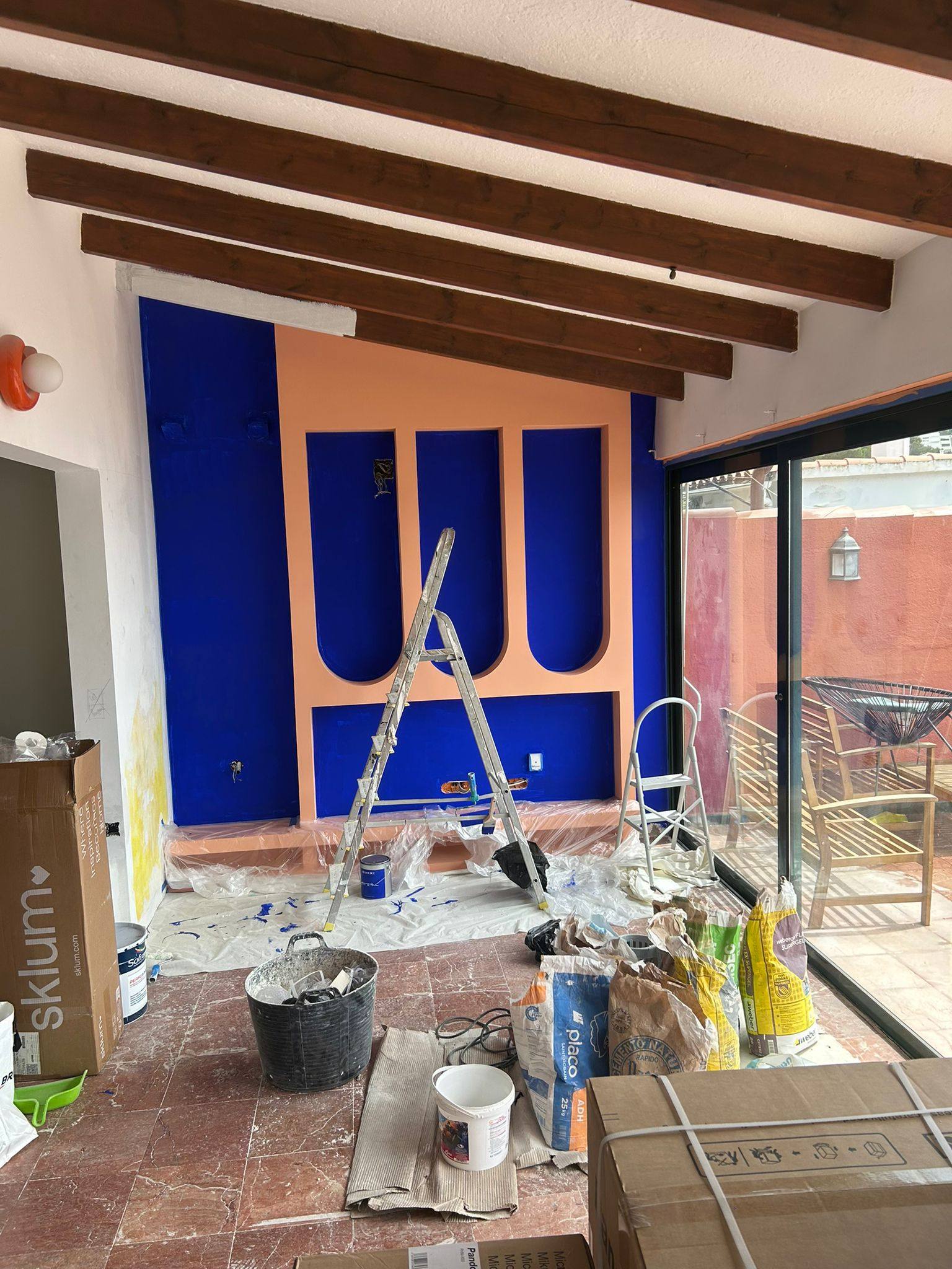 Avant : véranda encombrée en fin de chantier de peinture à Montpellier, bâches, pots, échelle et poussières au sol